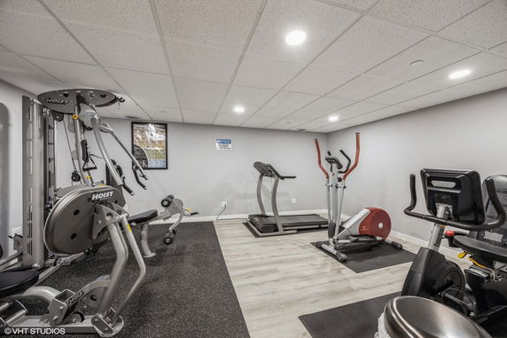 Room with exercise equipment including treadmill and elliptical machine.