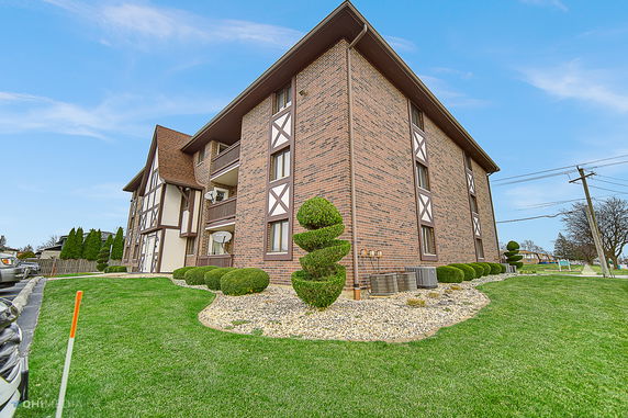 Front view of a multi-story brick building with decorative trim.