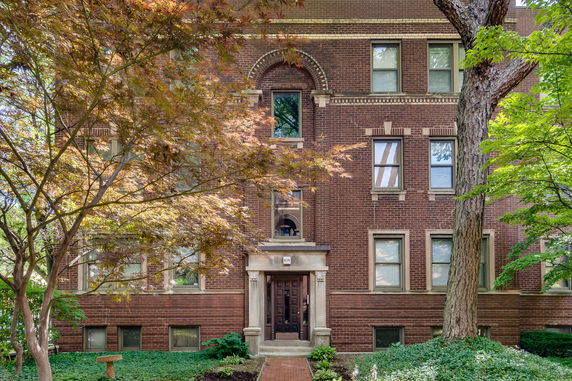 Front view of a multi-story brick building with multiple windows and a central entrance.