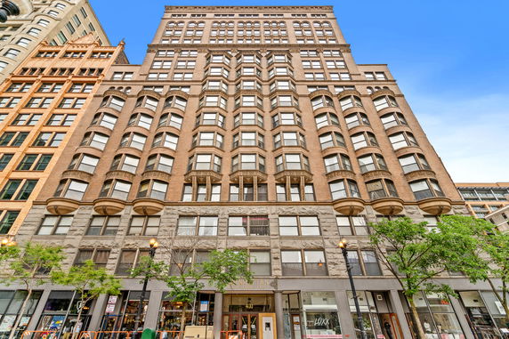 Front view of a multi-story building with large windows and architectural detailing.