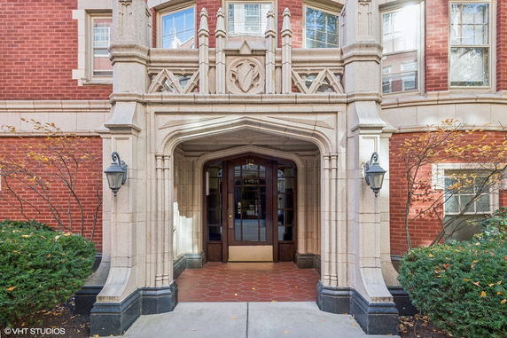 Front view of a building entrance with intricate stonework and arched doorway.