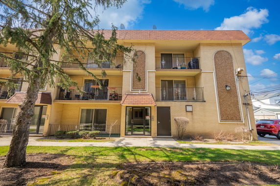 Front view of a multi-story apartment building with balconies.