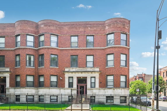 Front view of a three-story brick building with multiple windows and a central entrance.