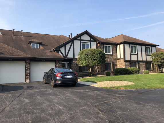 Front view of a two-story house with a garage and driveway.