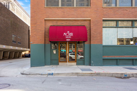 Front view of a building entrance with a red canopy labeled 'Moser Building 621'.