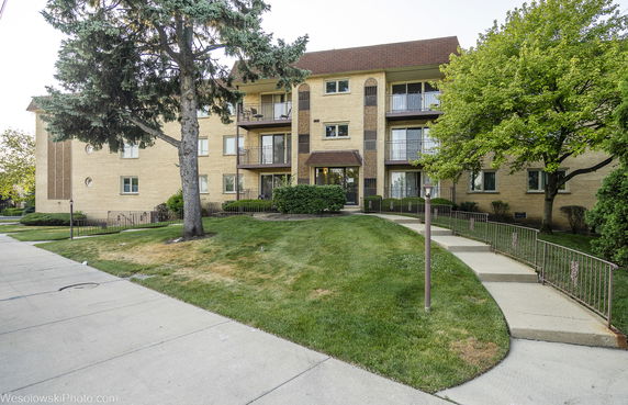 Front view of a multi-story apartment building with balconies.