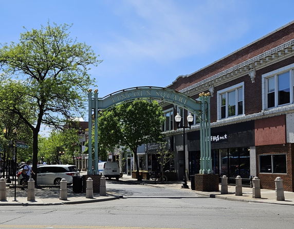 Street view with an archway labeled 'Lincoln Square' and adjacent building facades.