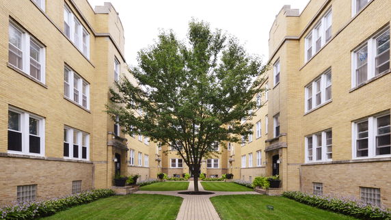 View of a courtyard surrounded by yellow brick apartment buildings.