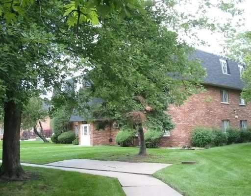 Front view of a two-story brick house with a steep roof.
