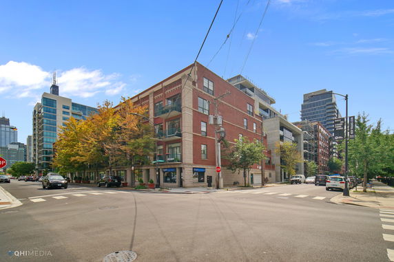 Front view of a multi-story brick building on a street corner.