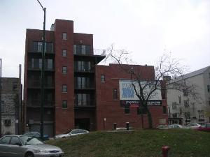 Front view of a multi-story brick building with balconies.