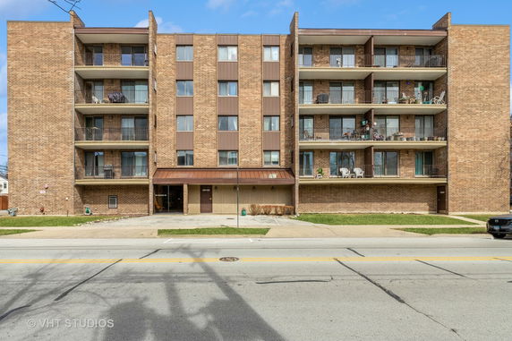 Front view of a multi-story apartment building with balconies.