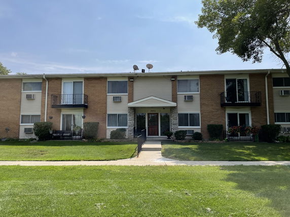 Front view of a two-story apartment building with multiple balconies.