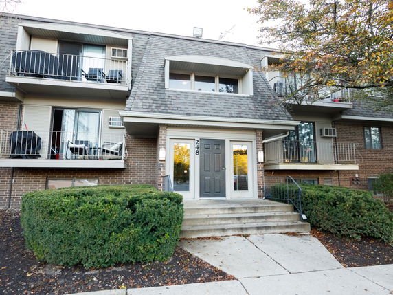 Front view of a multi-story building with balconies and entry steps.
