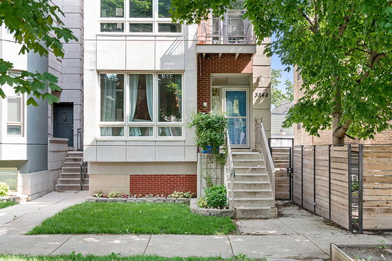 Front view of a modern multi-story house with large windows and a blue front door.