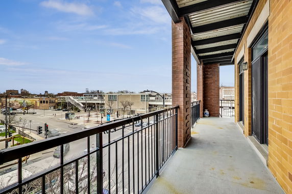 Balcony overlooking an urban intersection and buildings.