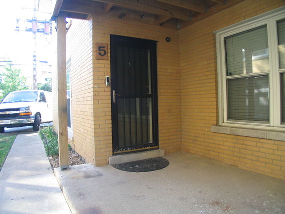 Front view of a building with a covered entrance and a brick exterior.