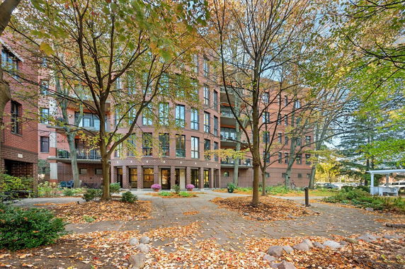 Front view of a multi-story brick apartment building with balconies.
