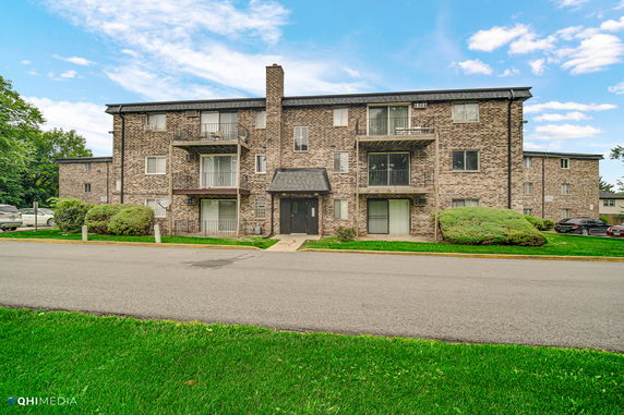 Front view of a multi-story brick apartment building.