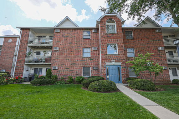 Front view of a multi-story brick building with balconies.