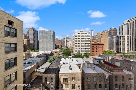 Panoramic view of a cityscape with multiple high-rise buildings and rooftops.