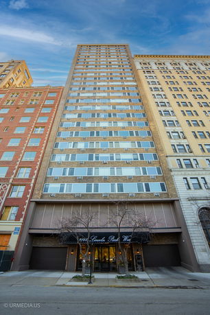 Front view of a tall apartment building with multiple windows and entrances.