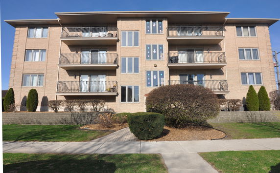 Front view of a multi-story apartment building with balconies.