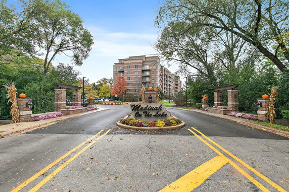 Front view of a multi-story residential building with a landscaped entrance.