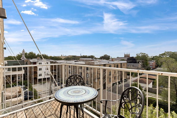 View from a balcony showing surrounding residential buildings and skyline.