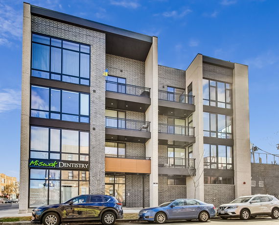 Front view of a modern multi-story commercial building with large windows and balconies.