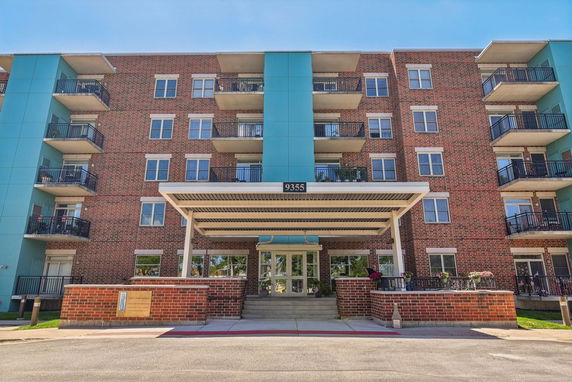 Front view of a multi-story residential building with balconies.