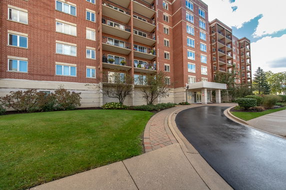 Front view of a multi-story apartment building with a brick facade.