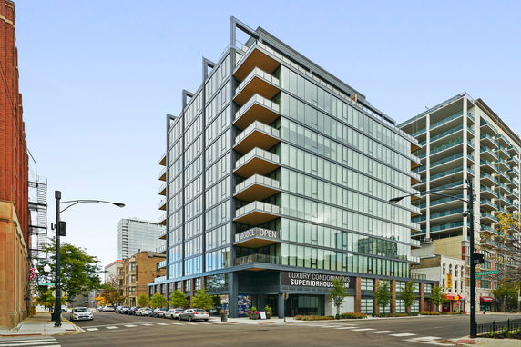 Front view of a modern multi-story condominium building with glass exterior.