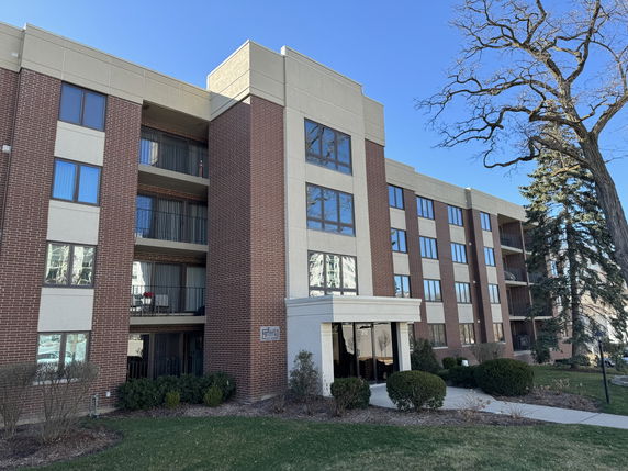 Front view of a multi-story residential building with brick facade and balconies.