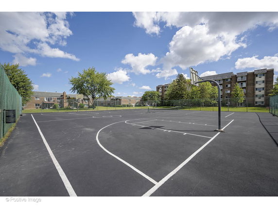 Basketball court with residential buildings in the background.