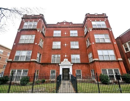 Front view of a multi-story brick apartment building with large windows and decorative elements.