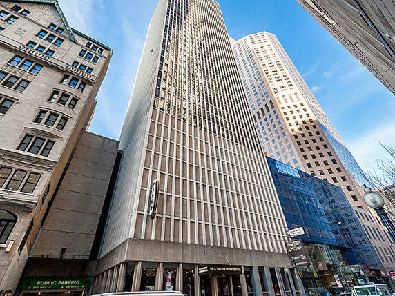 Front view of a tall office building in a city setting.