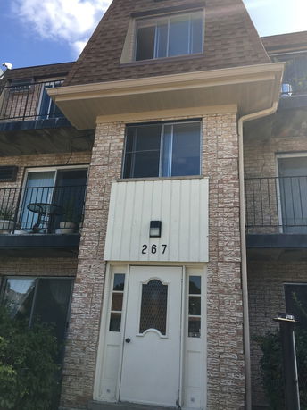 Front view of a multi-story residential building with balconies.