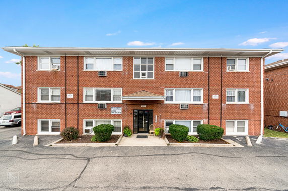 Front view of a multi-story brick apartment building.