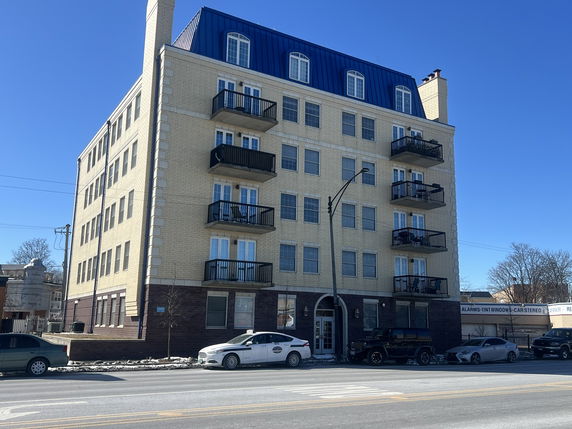 Front view of a multi-story apartment building with balconies.