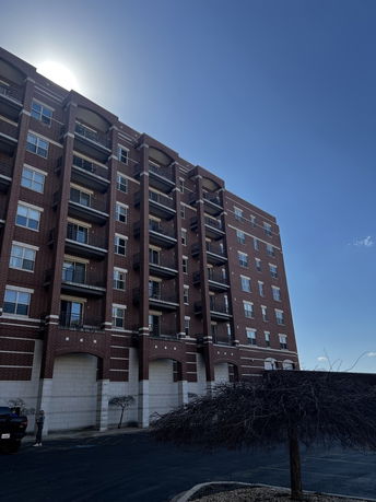 Front view of a multi-story brick building with balconies.