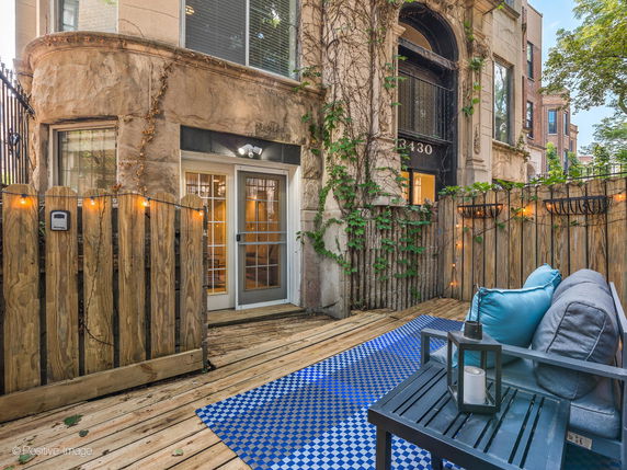 Front view of a building with an outdoor patio area featuring string lights and seating.