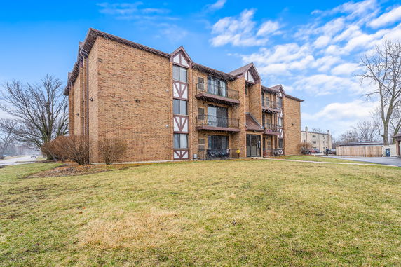Front view of a multi-story brick building with balconies.