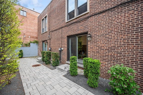 Brick facade of a two-story building with sliding glass doors.