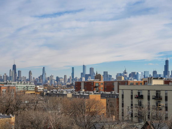 Panoramic view of a city skyline with tall buildings and residential areas in the foreground.