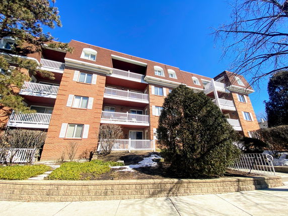 Front view of a multi-story apartment building with balconies.