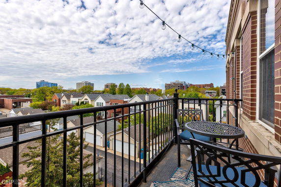 Balcony view overlooking a residential neighborhood with distant buildings.