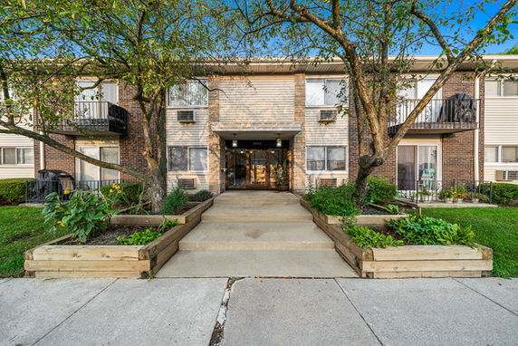 Front view of a two-story apartment building with balconies and a central entrance.