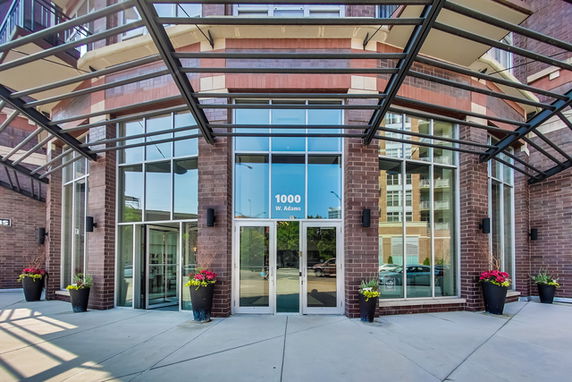 Front view of a modern building entrance with large glass doors and windows.