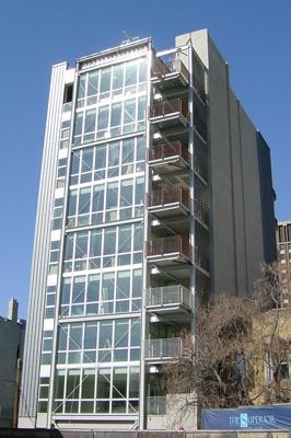 Front view of a multi-story building with large glass windows and balconies.